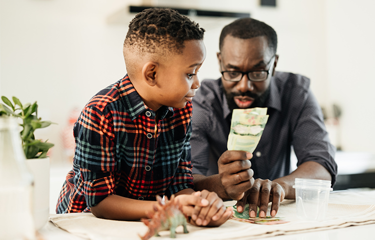 Un parent brandit de l'argent sous le regard de son enfant.